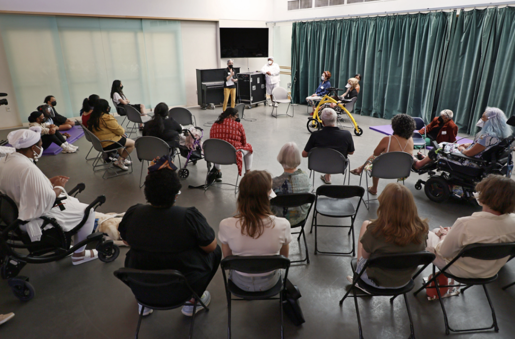 A group of individuals seated in chairs around speaker Professor Vic Marks.